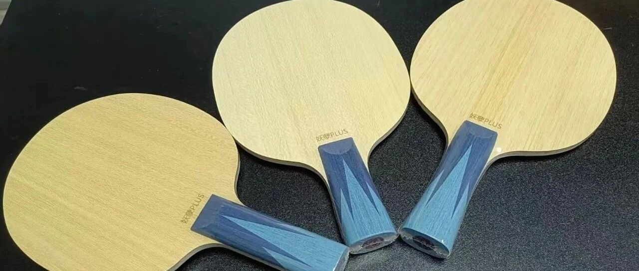 Three penhold blades with distinctive blue handles arranged on a dark surface