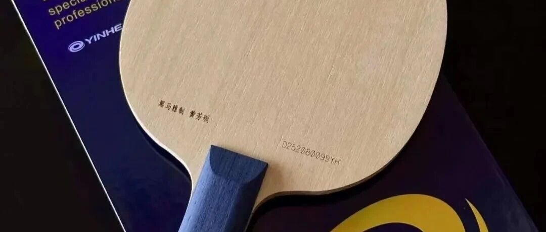 Yinhe table tennis blade resting on its box, showing the face and penhold handle