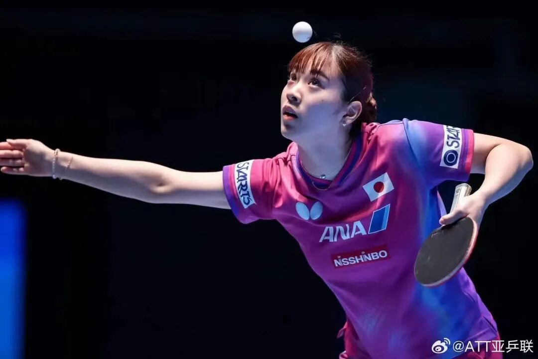 Japanese female table tennis player Nagasaki Miyu in action, mid-serve during a competitive match
