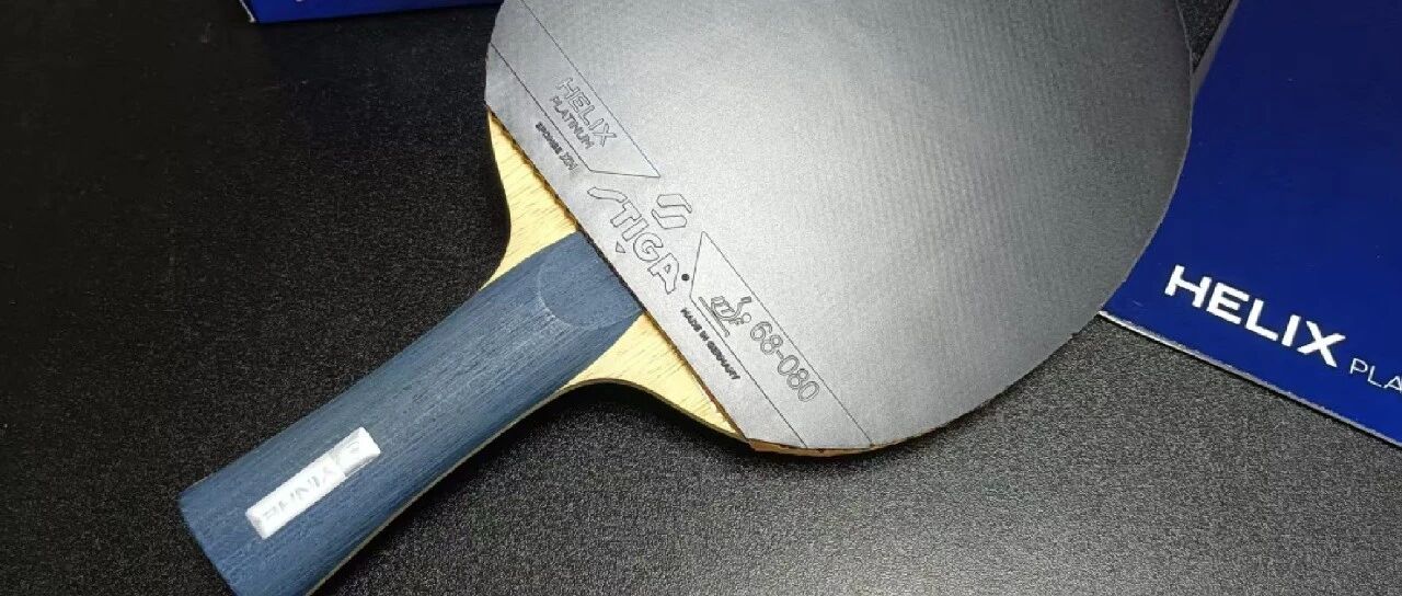 A Stiga Helix Platinum blade mounted with rubber, photographed on a table tennis surface
