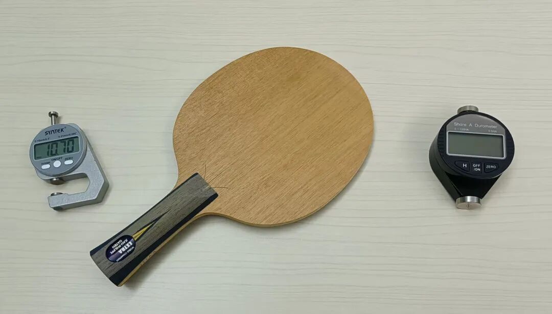 A table tennis blade photographed with measuring instruments showing thickness and hardness readings