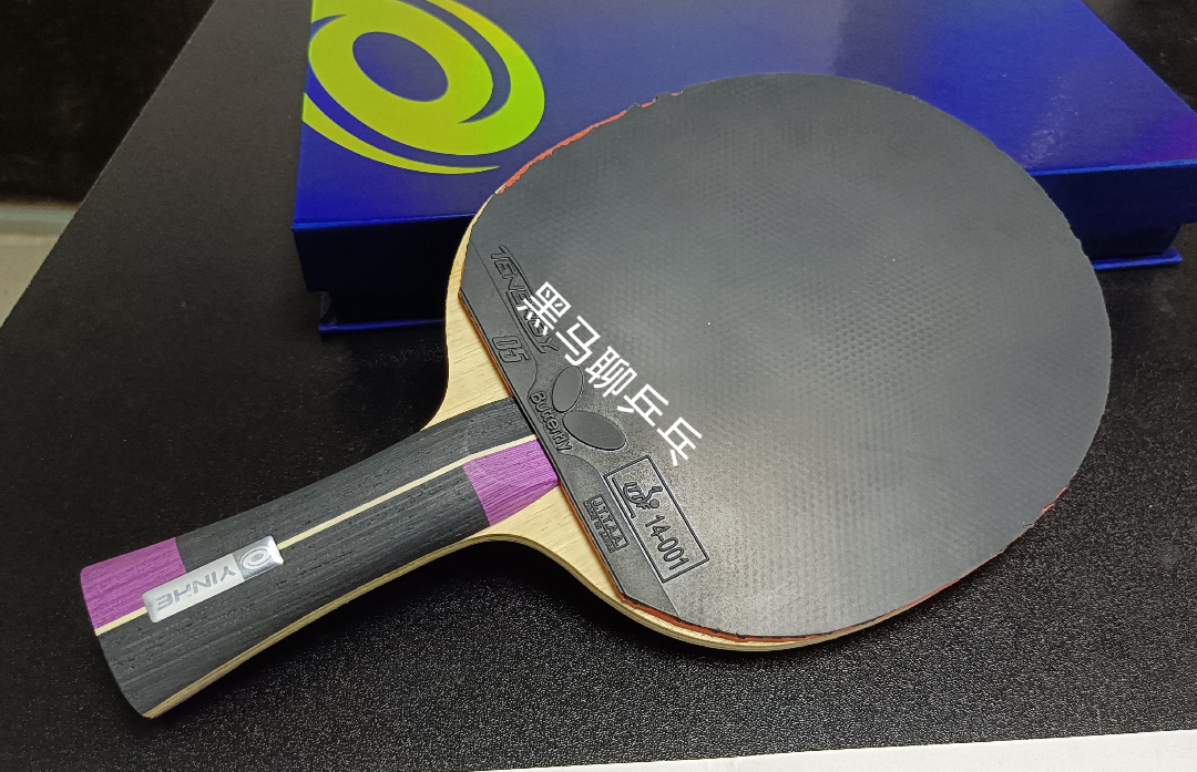 Player preparing to loop with fresh Tenergy 05 rubber on forehand side