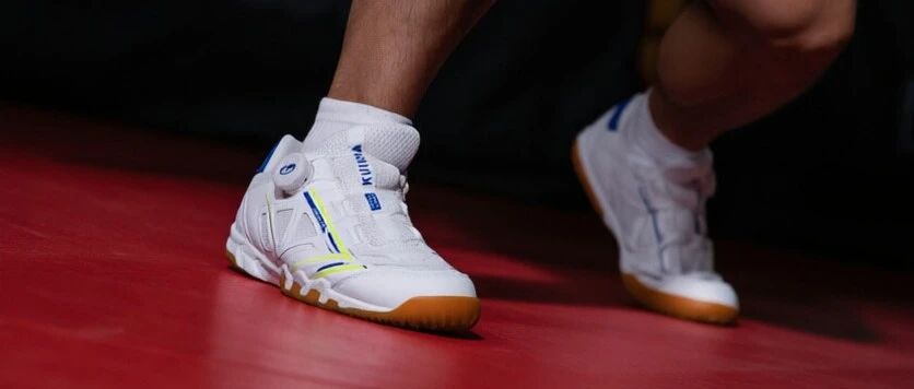 Decathlon Kuikma 560 BOA table tennis shoe being worn on a red court floor