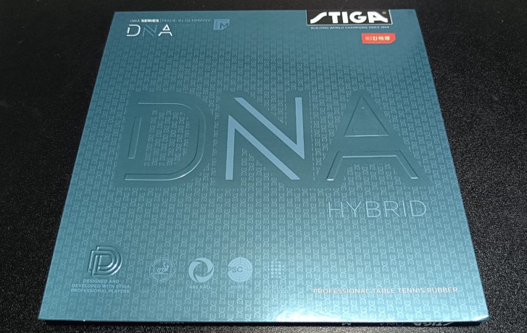Two table tennis paddles with STIGA DNA rubbers lying on a blue table surface