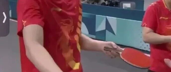 Table tennis player handing off a racket courtside at the Paris Olympics