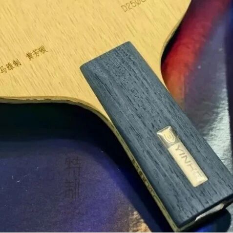 Close-up of a table tennis blade handle showing the Yinhe logo