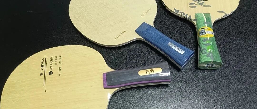 Three table tennis blades laid flat with their handles displayed, showing Yinhe and Butterfly equipment