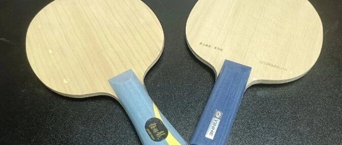 Two Yinhe all-wood penhold blades side by side on a dark surface