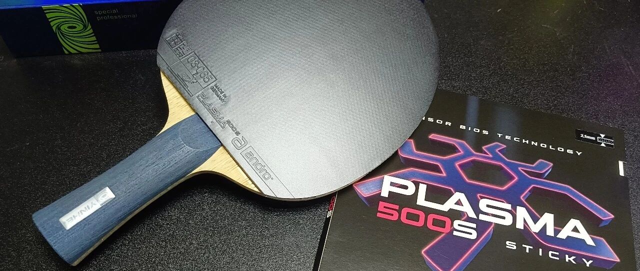 A table tennis paddle assembled with Plasma 500S sticky rubber beside its packaging