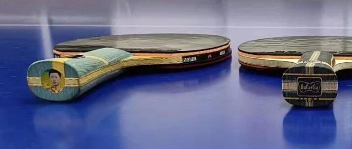 Two table tennis blades resting on a blue table