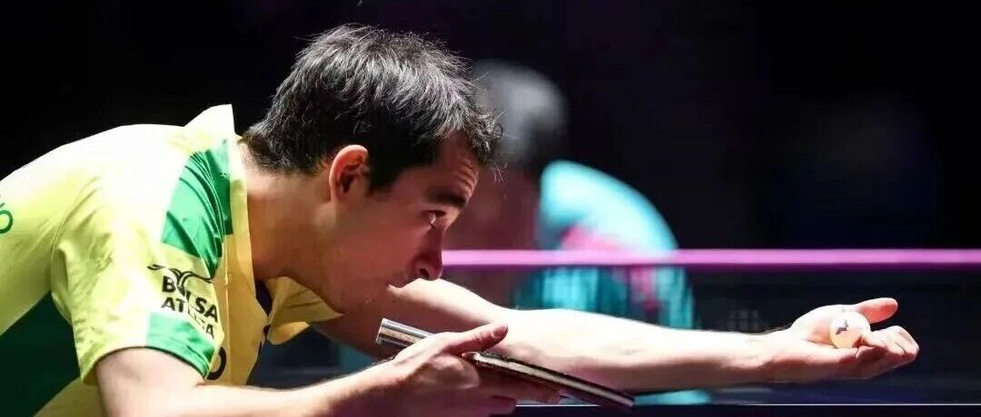 Table tennis player crouching low over the table to serve
