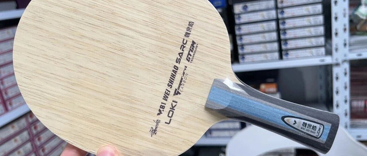 Loki Wei Shihao SARC outer carbon blade held in a table tennis store