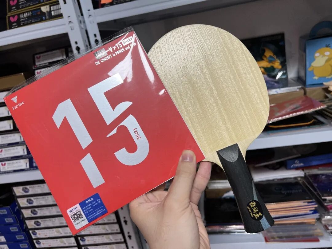 Victas V15 Sticky Max rubber in packaging held beside a table tennis blade