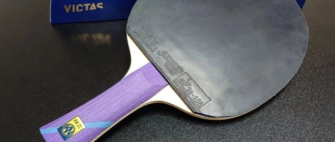 VICTAS blade with purple KN-ZC handle beside a blue blade box on a dark surface, Hurricane rubber visible