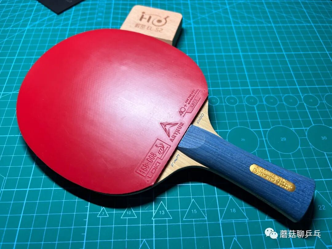 Loki Arthur Asia rubber mounted on a paddle with blue-handled blade on a cutting mat