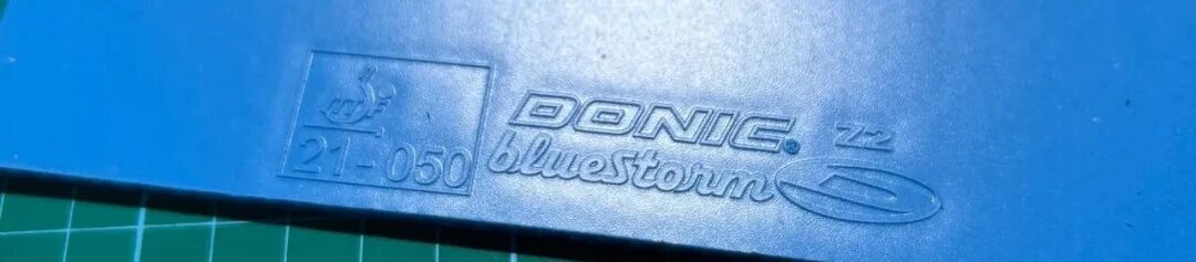 DONIC Bluestorm Z2 rubber laid out beside a Niwa all-wood blade for size comparison