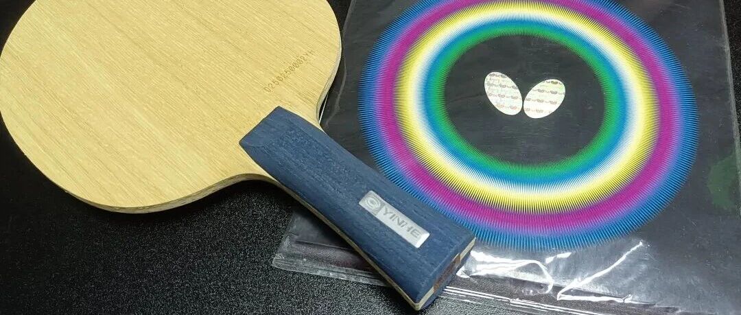 A Yinhe blade paired with a Butterfly Tenergy 80 rubber sheet on a dark table