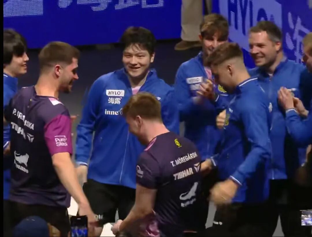 Fan Zhendong smiling with his Saarbrucken teammates after winning the Champions League title