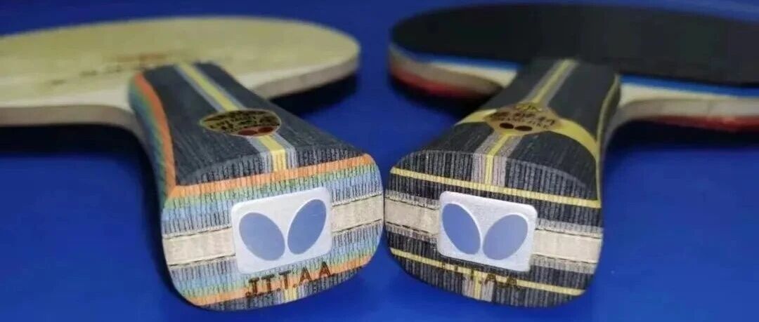 Two table tennis paddles with rubbers displayed against colorful holographic box packaging, showing blade construction details