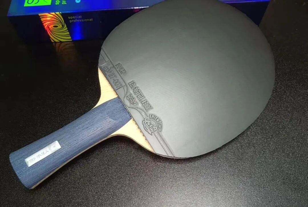 Wang Chuqin close-up at table during match showing forehand Hurricane rubber
