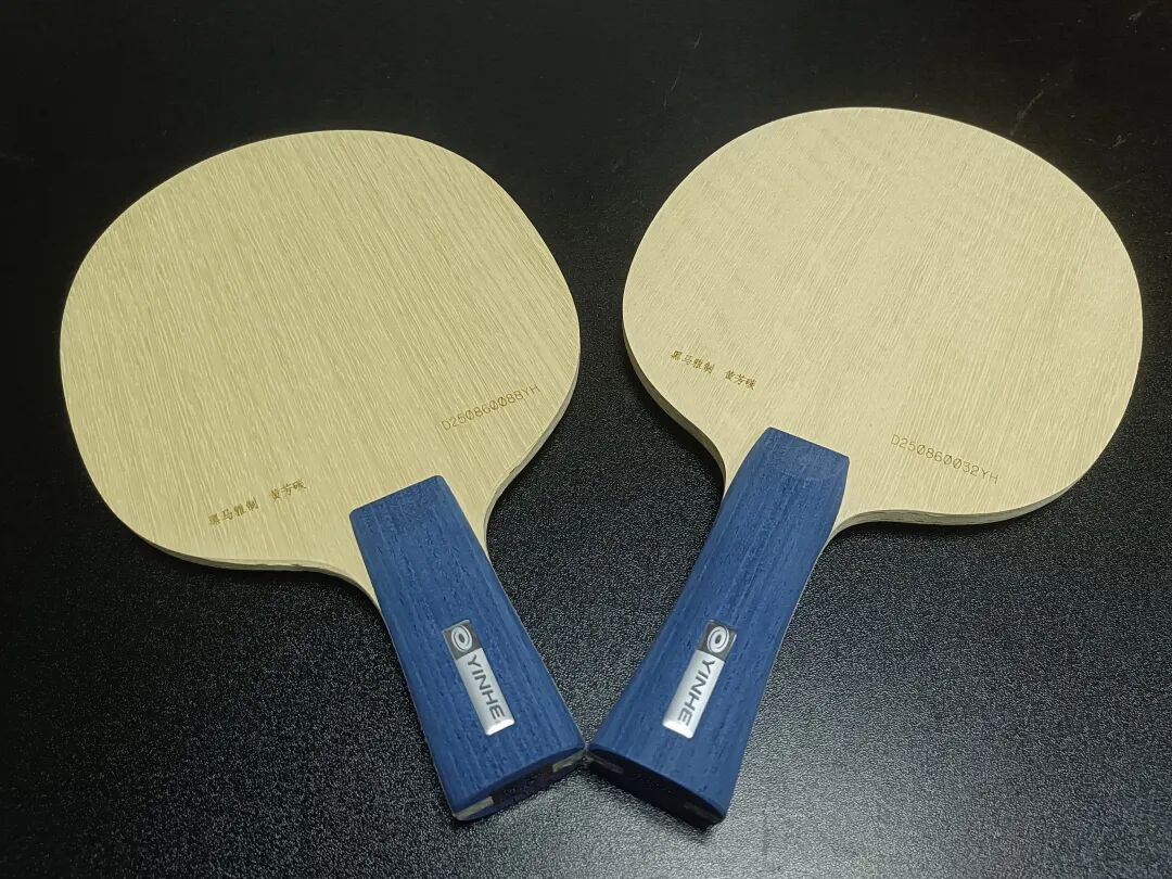 Two custom table tennis blades placed side by side on a dark surface showing the Yinhe KLC construction