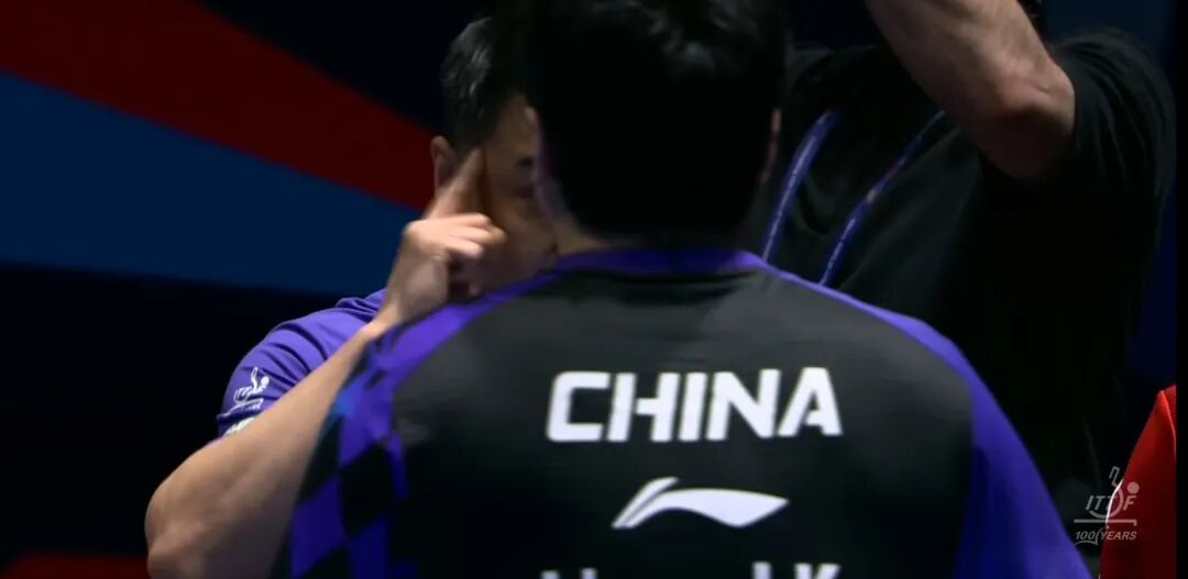 Coach Wang Hao speaking to Liang Jingkun at the changeover during dramatic five-game match